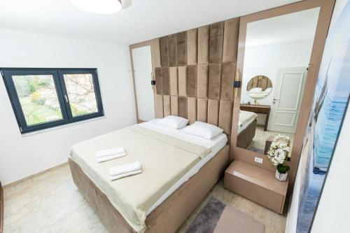 een slaapkamer met een groot bed en een spiegel bij Lira Suites in Donji Štoj