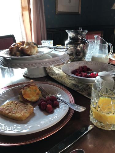 a table topped with plates of food and fruit at The Nauvoo Grand Bed & Breakfast in Nauvoo
