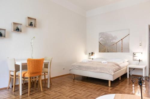 Schlafzimmer mit einem Bett, einem Tisch und Stühlen in der Unterkunft Convenient 1BR Apartment in the Heart of Vienna in Wien