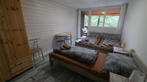 sypialnia z 2 łóżkami i oknem w obiekcie Chata U Rybáře w mieście Bítov