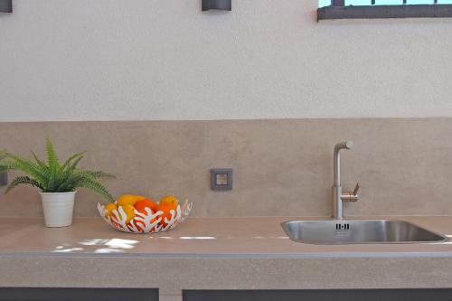 a kitchen counter with a sink and a bowl of fruit at Apartment Limoni in Sutivan