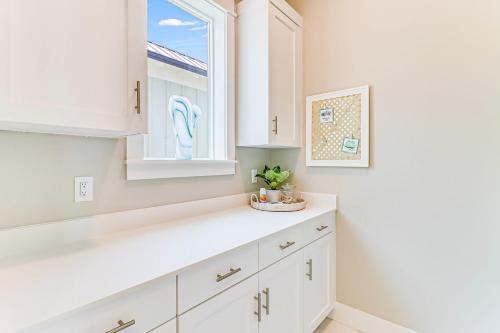 a kitchen with white cabinets and a window at Waterfront Wonderland in Rockport