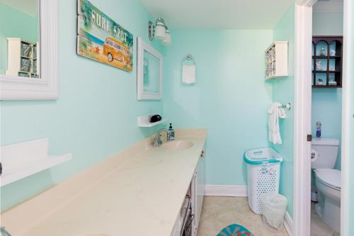 uma casa de banho com um lavatório branco e um WC. em Coastal Haven em Pensacola Beach