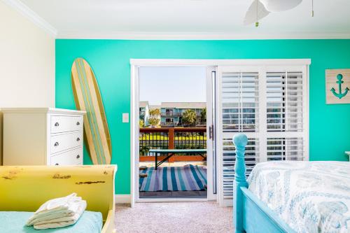um quarto com uma cama e uma porta para uma varanda em Coastal Haven em Pensacola Beach