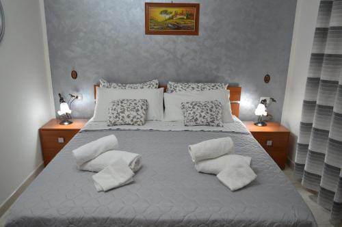 1 dormitorio con 1 cama blanca grande con almohadas en Bed and Breakfast Arcobaleno, en Casteltermini