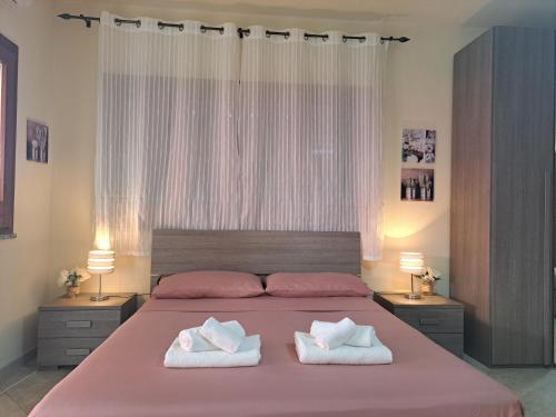 a bedroom with a large bed with two towels at Alice's House - Monolocale in Pula