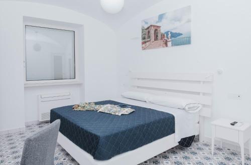 a white room with a bed and a window at A Gradillo holiday rooms in Ravello