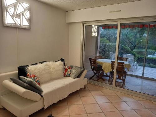 un salon avec un canapé et une table dans l'établissement Les Hauts du Golf Rez de jardin Piscine Tennis, à Saint-Raphaël