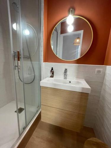 La salle de bains est pourvue d'un lavabo et d'une douche avec un miroir. dans l'établissement Studio Biarritz 2 min Halles, 3 min plages, plein centre., à Biarritz