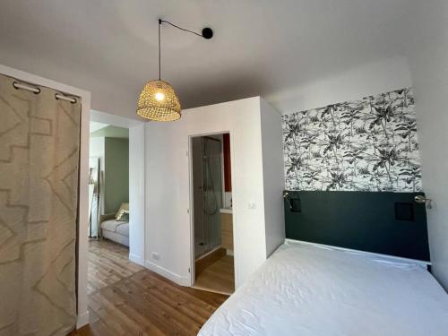 1 dormitorio con 1 cama y una pintura en la pared en Studio Biarritz 2 min Halles, 3 min plages, plein centre. en Biarritz