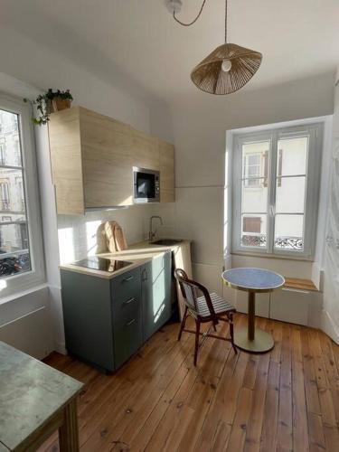 - une cuisine avec une table, un évier et une table dans l'établissement Studio Biarritz 2 min Halles, 3 min plages, plein centre., à Biarritz