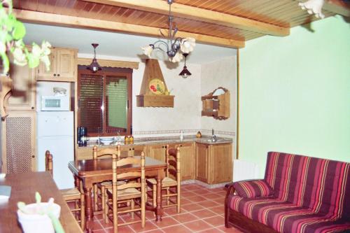 cocina y comedor con mesa y sofá en APARTAMENTOS Y HABITACIONES RURALES "El Corral", en Cañizares