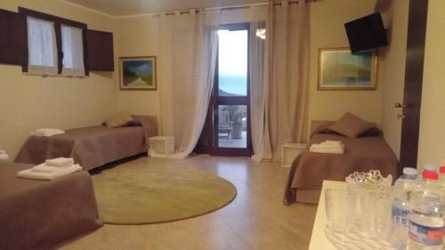 Zimmer mit 2 Betten und einem Wohnzimmer mit Fenster in der Unterkunft Raggi di Sole in Custonaci