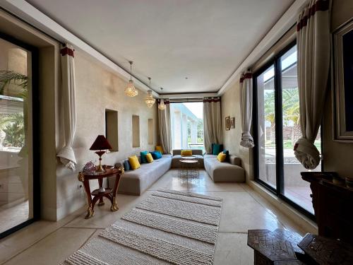 a living room with couches and a large window at Les Jardins de Kesali in Marrakesh