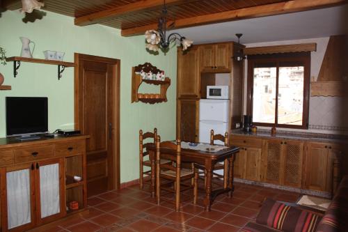 cocina con mesa de madera y cocina con nevera en APARTAMENTOS Y HABITACIONES RURALES "El Corral", en Cañizares