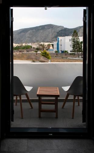 a table and two chairs on a balcony with a view at Sun Springs Suites in Kamari