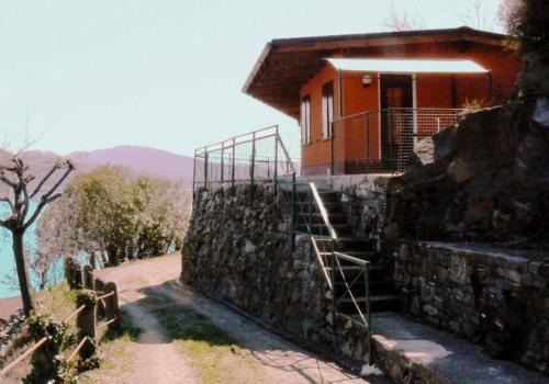 a house on top of a rock wall with a staircase at Lakeview Cannobio Camping & Resort in Cannobio