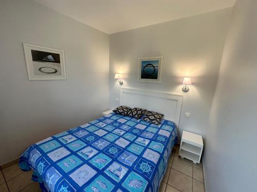 une chambre avec un lit et deux tableaux au mur dans l'établissement Charmant appartement T2 pour 4 personnes vue mer sables d'olonne, à Saint-Jean-dʼOrbetiers