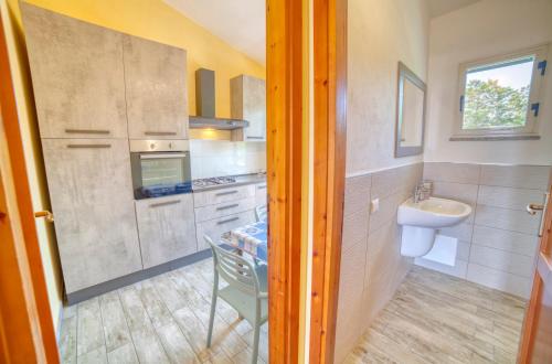 a small kitchen with a sink and a toilet and a sink at Casa Vacanza Sole & Luna in Stintino