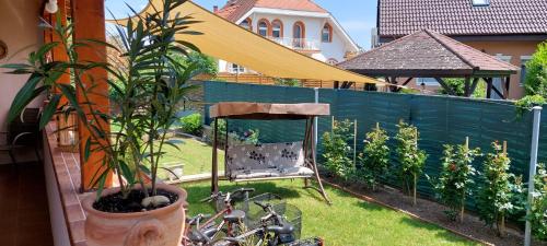 a garden with a chair and plants and a fence at Forrás-G Vendégház in Bük