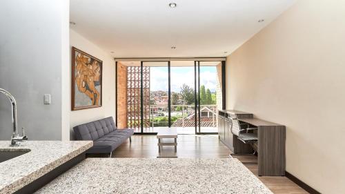 a kitchen and living room with a couch and a table at Hotel & Suites en Cuenca, Venue Batán in Cuenca