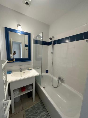 une salle de bain avec un lavabo, une baignoire et une douche dans l'établissement Charmant appartement T2 pour 4 personnes vue mer sables d'olonne, à Saint-Jean-dʼOrbetiers