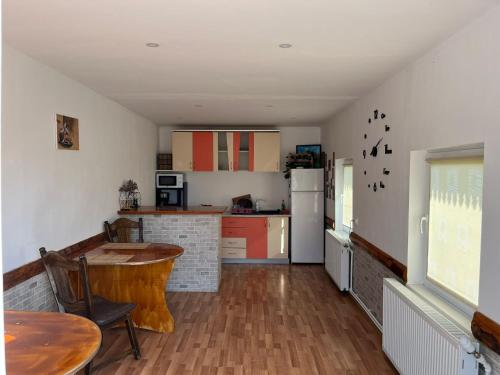 a kitchen with a wooden table and a kitchen with a counter at Casa Ilinca in Filioara