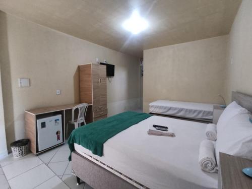 a bedroom with two beds and a television in it at Amazônia Praia Hotel in Tibau