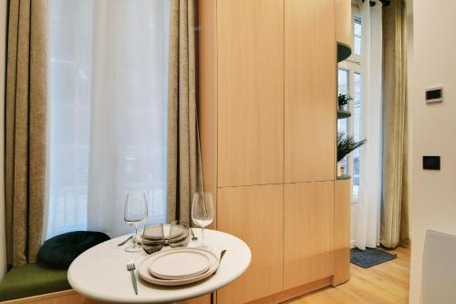 - une table blanche avec deux verres à vin dans l'établissement Attractive studio - 2P - Auteuil - Parc des Prince, à Paris
