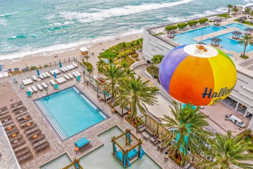 an overhead view of a pool and beach with a large beach ball at Splendid Resort - Oceanview 1BDR & 1BA Apt Right on the Beach, Heated pool, GYM in Hollywood