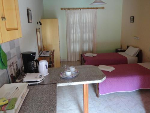 a hotel room with two beds and a table in a room at Stamatela Studios in Paleokastritsa