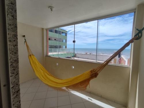 a hammock in a room with a view of the beach at Amazônia Praia Hotel in Tibau