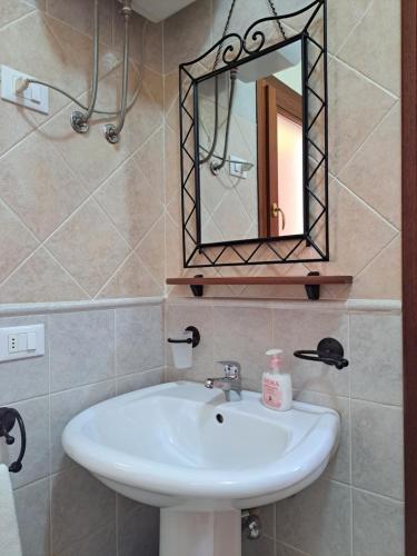 a bathroom with a sink and a mirror at Alice's House - Monolocale in Pula
