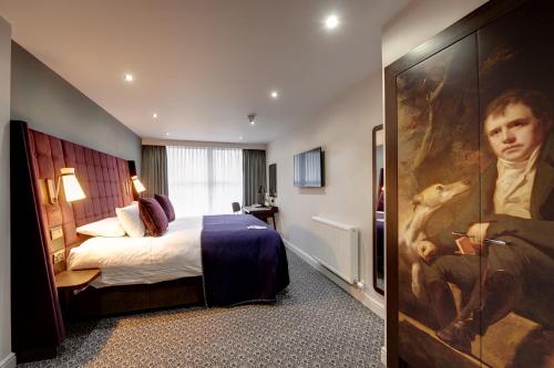 a hotel room with a bed and a painting on the door at Mercure Inverness Hotel in Inverness