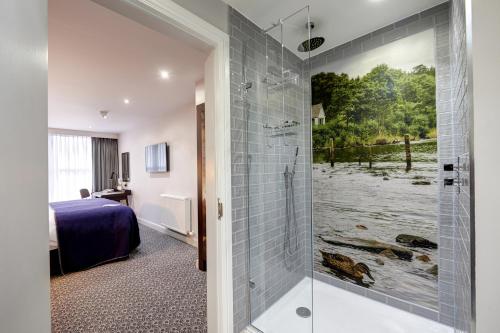 a hotel room with a shower and a bedroom at Mercure Inverness Hotel in Inverness