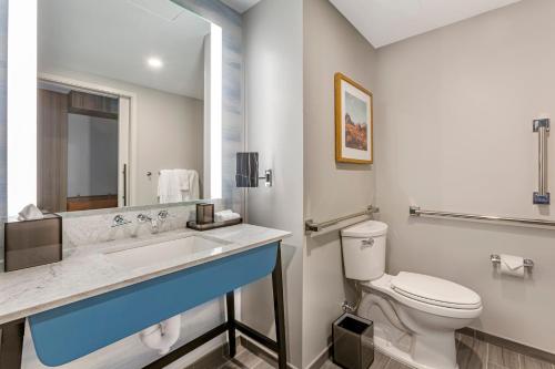 a bathroom with a toilet and a sink and a mirror at Omni Tempe Hotel at ASU in Tempe