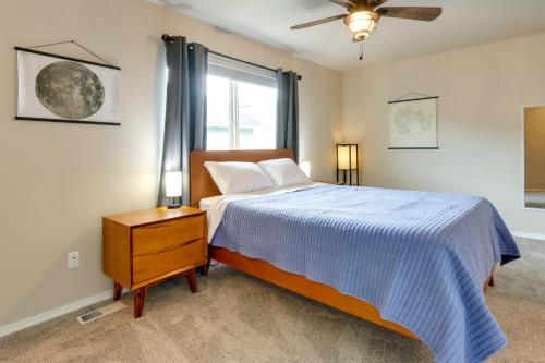 una camera da letto con un letto con un piumone blu e una finestra di Alaska Retreat with Balcony, Near Earthquake Park! ad Anchorage