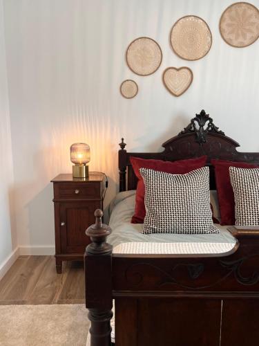 a bedroom with a bed with red pillows and a table at Casa Bizarra in Castanheira de Pêra