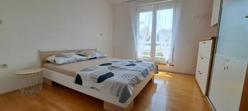 ein Schlafzimmer mit einem Bett und einem großen Fenster in der Unterkunft Little Sunlight Oasis in Split