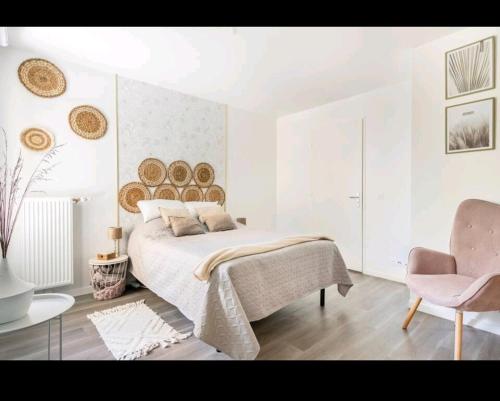 a white bedroom with a bed and a chair at Appartement Cosy à 8 min Disney 20 min Paris in Montévrain