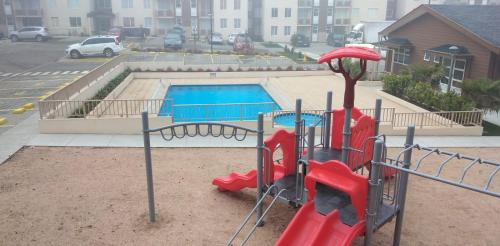 a playground with a slide and a swimming pool at Apartamento Villarrica in Villarrica
