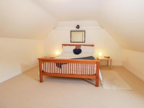 a bedroom with a wooden bed in a attic at The Annexe in Petworth
