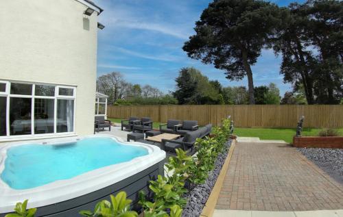 a backyard pool with a hot tub and patio furniture at The Willows in Laceby