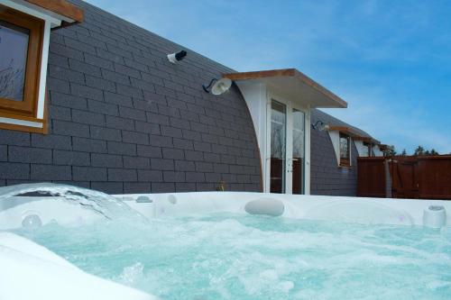 a hot tub in front of a house at Dragons Den in Norwich