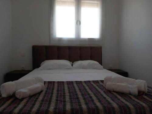 a bedroom with a large bed with two pillows on it at Wooden Home in Ermioni