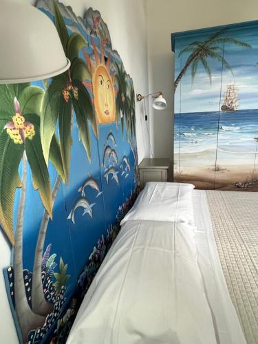 a bedroom with a blue wall with a palm tree mural at Baglio Mazzara in Custonaci