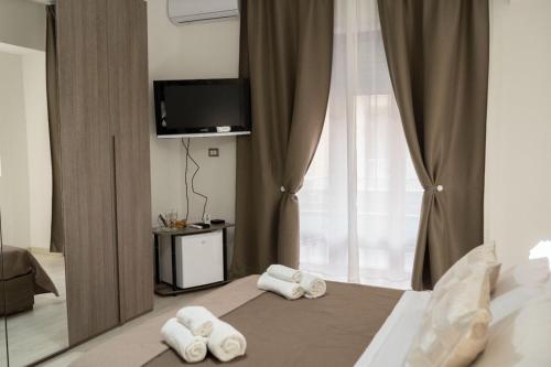 1 dormitorio con 1 cama con toallas en B&BSCICCHERI en Castellammare di Stabia