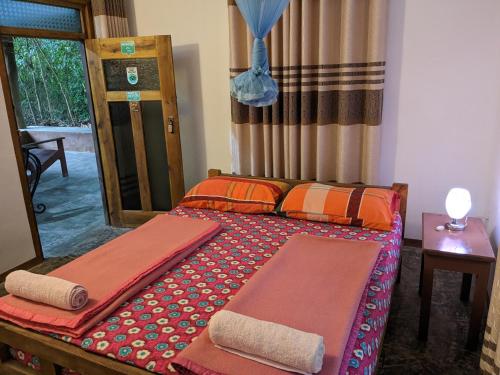 Buttala的住宿－Yala Avian Eye Safari，一间卧室配有一张带两张垫子的床