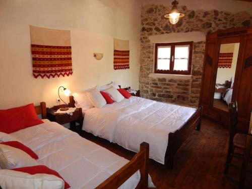 a bedroom with two beds and a window at Traditional stone house camari in Apóstoloi