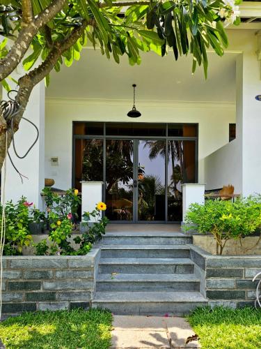 a house with stairs leading to the front door at Catsen Bungalows & Pool Phan Thiet in Phan Thiet